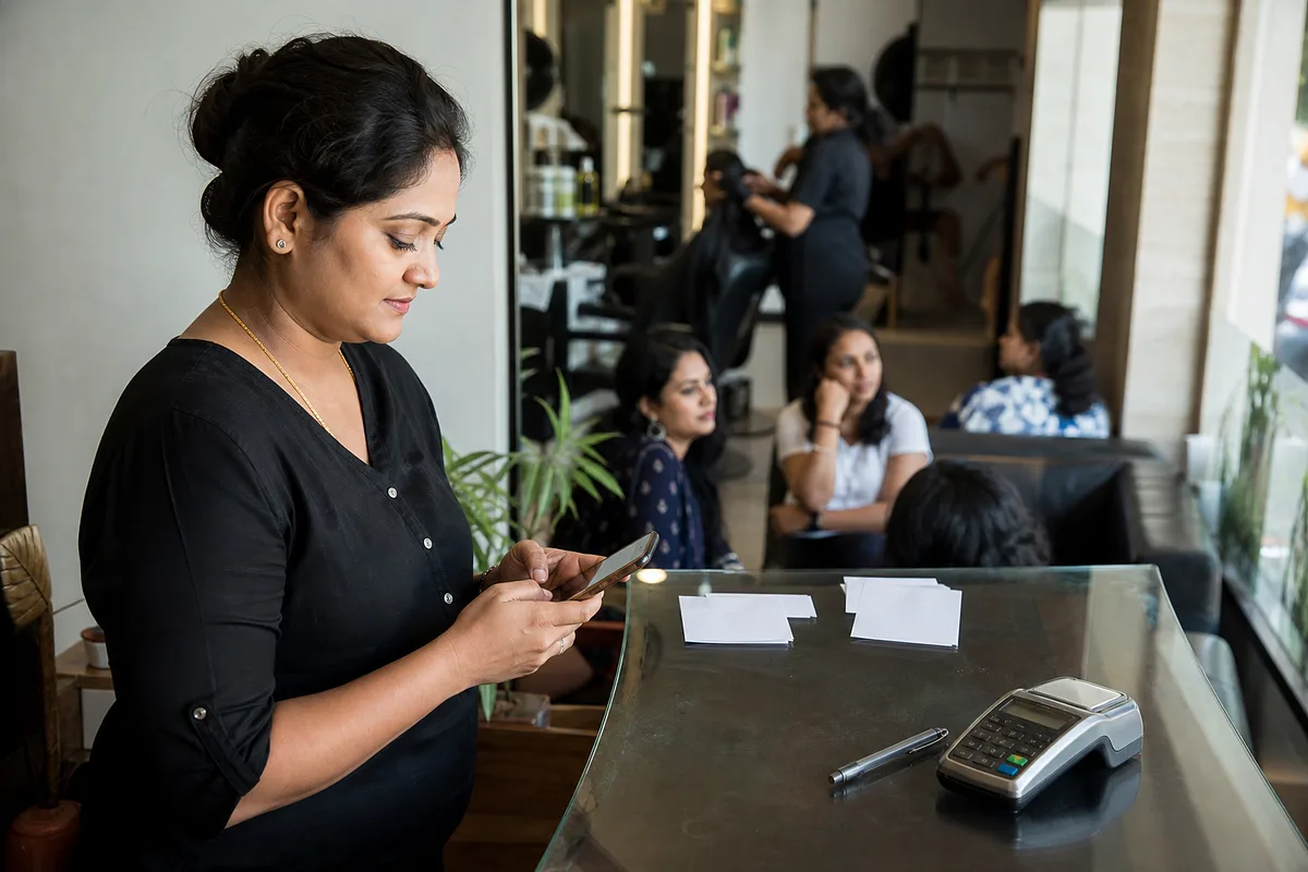 Salon manager coordinating customer bookings from a phone